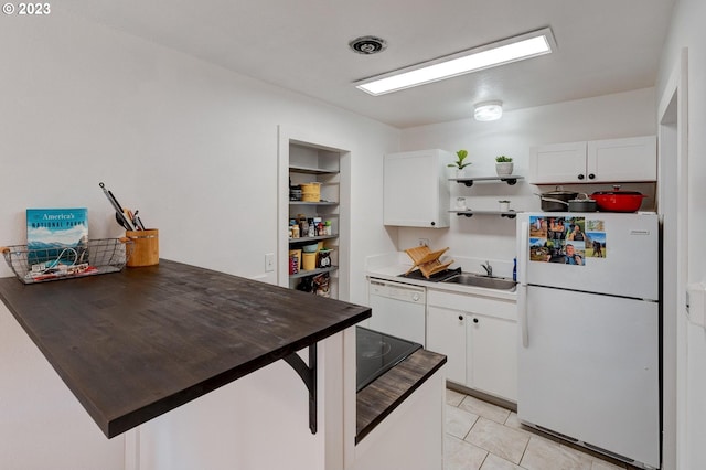 kitchen featuring light tile floors, white appliances, white cabinetry, and sink