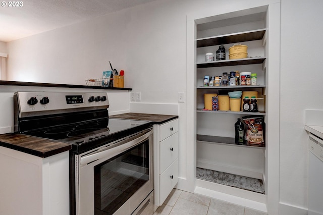 kitchen featuring wooden counters, light tile flooring, white dishwasher, and electric range