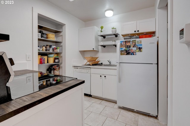 kitchen featuring white cabinets, light tile floors, white appliances, and sink