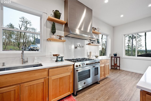 kitchen featuring range with two ovens, open shelves, a sink, ventilation hood, and light countertops