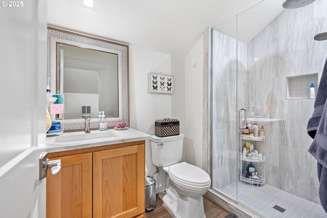 full bathroom with toilet, a shower stall, wood finished floors, and vanity