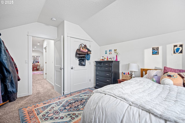 carpeted bedroom featuring a textured ceiling, vaulted ceiling, and a closet