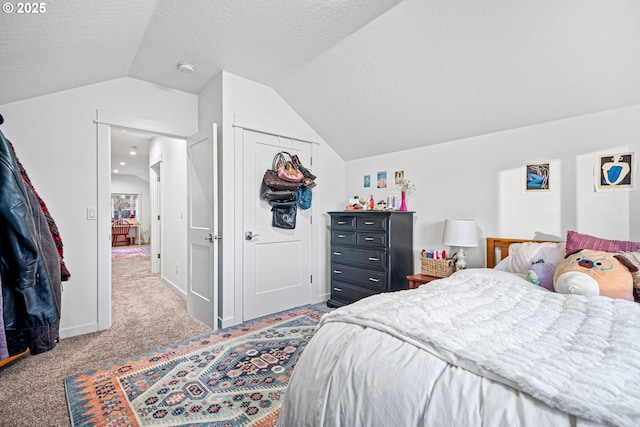 bedroom with lofted ceiling, carpet floors, and a textured ceiling