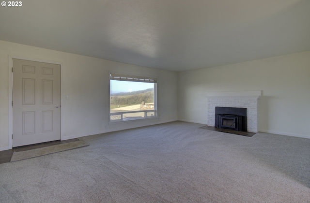 unfurnished living room with a fireplace and light colored carpet