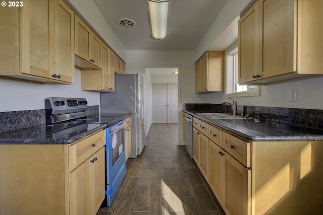 kitchen featuring dark hardwood / wood-style flooring, dark stone counters, light brown cabinets, appliances with stainless steel finishes, and sink