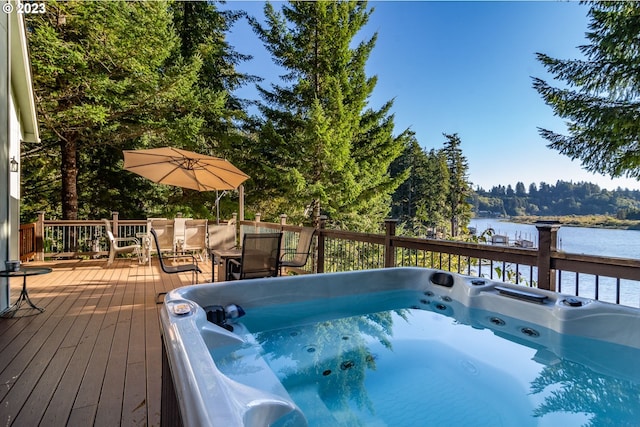 view of pool with a deck with water view and an outdoor hot tub