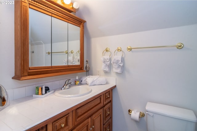 bathroom featuring toilet, tasteful backsplash, and oversized vanity