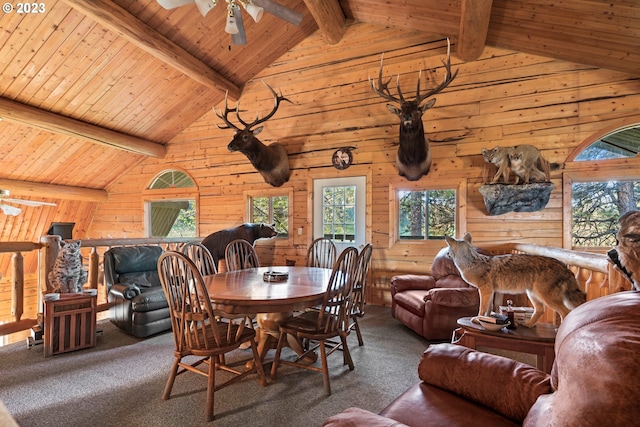 carpeted dining area featuring wooden walls, wood ceiling, ceiling fan, and lofted ceiling with beams