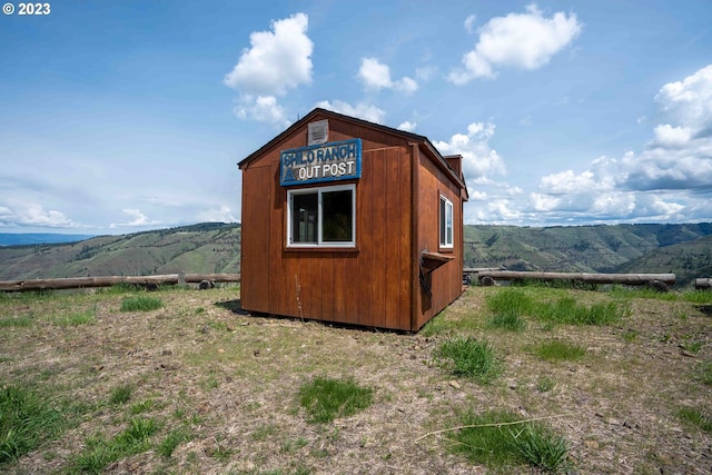 view of outdoor structure with a mountain view and a rural view