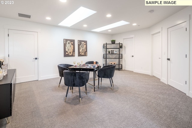 carpeted office space featuring a skylight