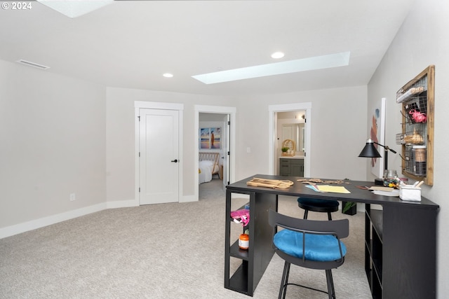 carpeted office featuring a skylight