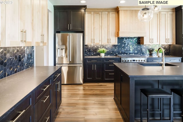 kitchen with light hardwood / wood-style floors, stove, stainless steel refrigerator with ice dispenser, sink, and backsplash