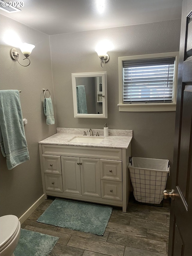 bathroom with wood-type flooring, toilet, and vanity