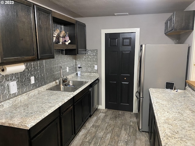 kitchen with tasteful backsplash, stainless steel appliances, hardwood / wood-style flooring, and sink