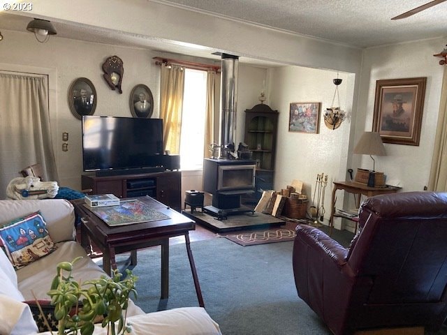 carpeted living room featuring a wood stove, ceiling fan, and a textured ceiling