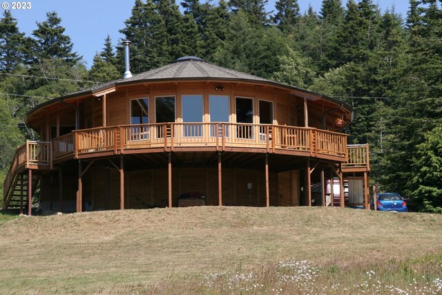 back of house with a lawn and a wooden deck