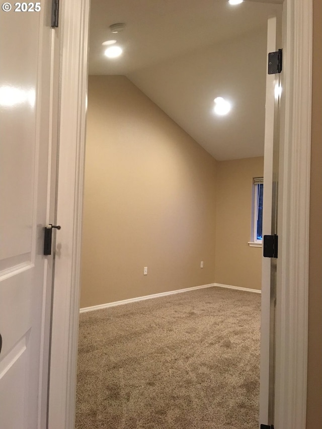 carpeted empty room featuring lofted ceiling