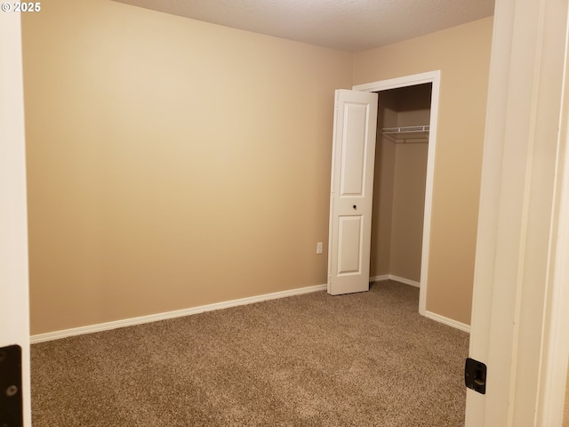 unfurnished bedroom with a closet, a textured ceiling, and carpet