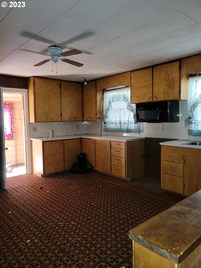 kitchen with ceiling fan and dark carpet