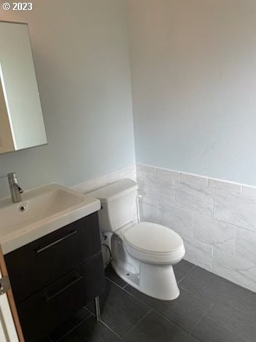 bathroom with tile floors, toilet, and vanity