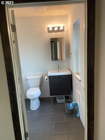 bathroom with tile floors, toilet, and vanity