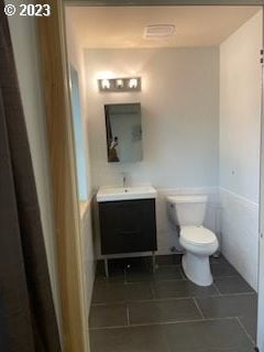 bathroom with tile flooring, toilet, and vanity