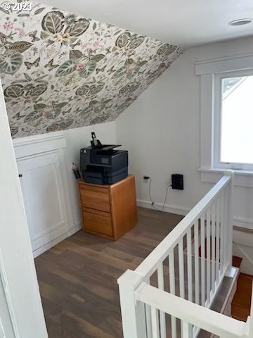 additional living space with vaulted ceiling and dark hardwood / wood-style flooring