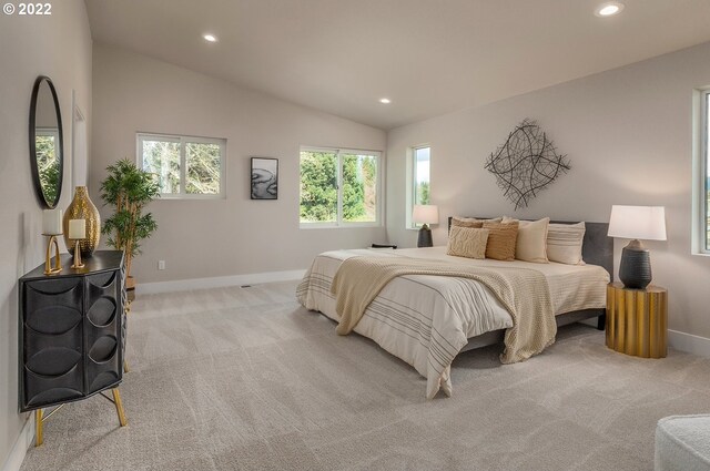 carpeted bedroom featuring multiple windows and vaulted ceiling