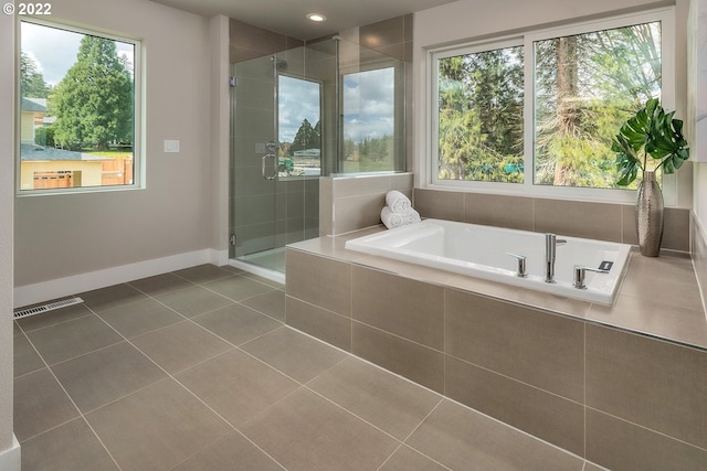 bathroom featuring a wealth of natural light, tile patterned floors, and plus walk in shower