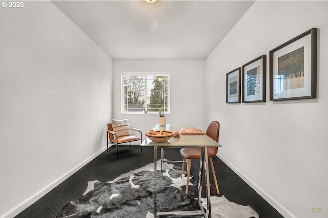 carpeted dining room with baseboards