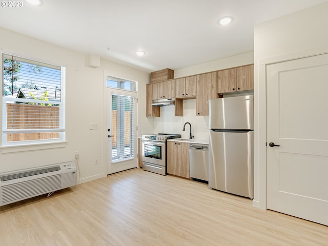 kitchen featuring light wood-type flooring, light brown cabinetry, appliances with stainless steel finishes, and sink