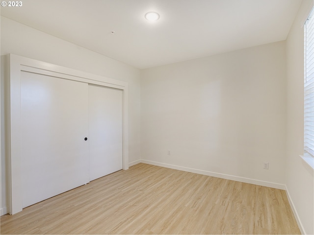 unfurnished bedroom featuring a closet and light hardwood / wood-style flooring