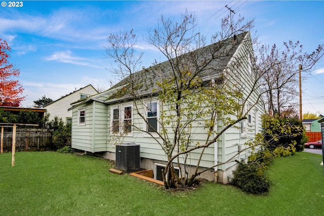 back of house with a lawn and cooling unit