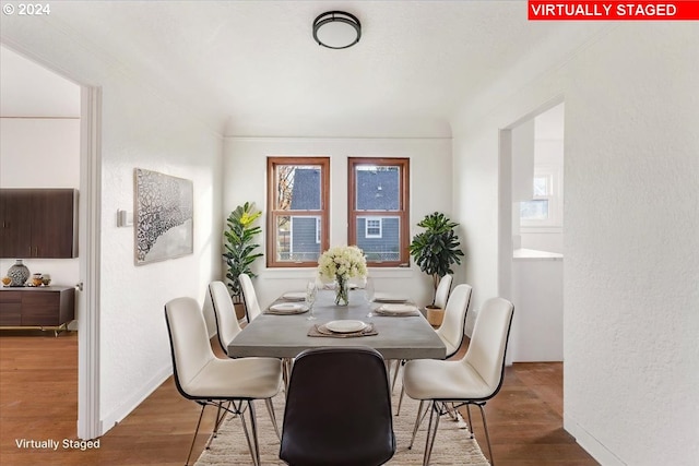 dining area with crown molding and dark wood-type flooring