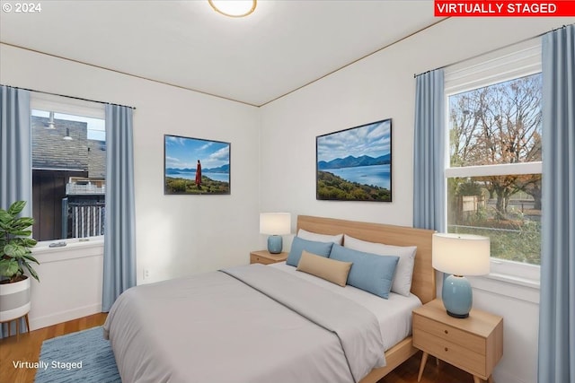 bedroom with hardwood / wood-style flooring and multiple windows