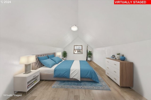 bedroom with light hardwood / wood-style floors and vaulted ceiling