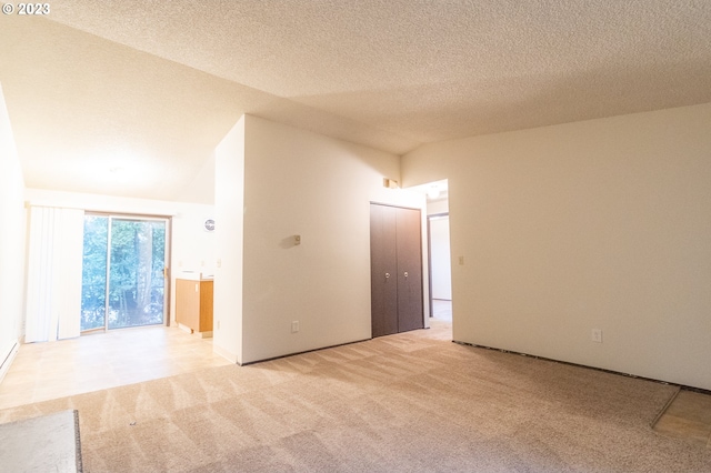 spare room with a textured ceiling and light colored carpet