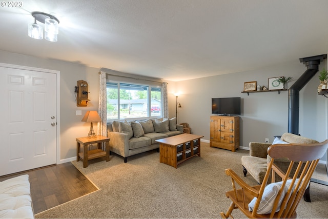 living room with light colored carpet and a wood stove