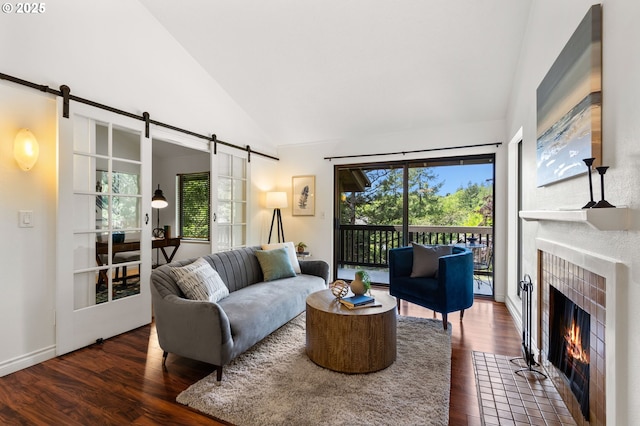 7730 SW Barnes Rd Unit B, Portland, OR 97225 - living room with a barn door, wood finished floors, a tile fireplace, and high vaulted ceiling