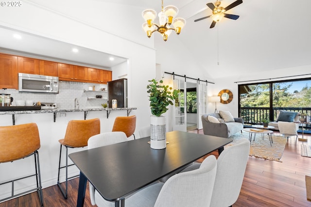 7730 SW Barnes Rd Unit B, Portland, OR 97225 - dining area with high vaulted ceiling, a barn door, a chandelier, a ceiling fan, and recessed lighting