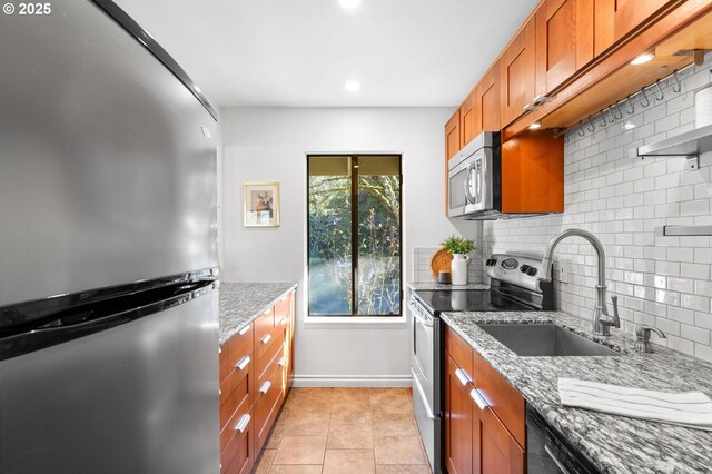 7730 SW Barnes Rd Unit B, Portland, OR 97225 - kitchen with appliances with stainless steel finishes, brown cabinets, backsplash, light stone counters, and recessed lighting