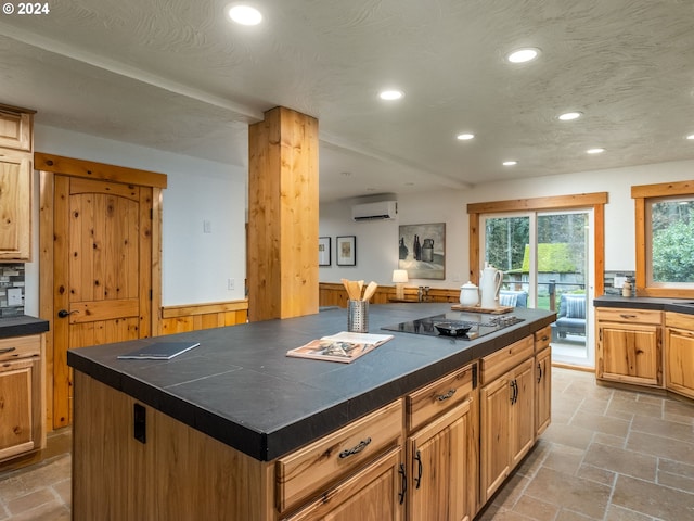 kitchen with tasteful backsplash, black electric cooktop, a center island, and a wall unit AC