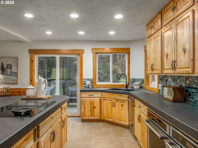 kitchen featuring sink, a textured ceiling, backsplash, and black electric cooktop