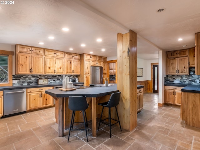 kitchen with a center island, tasteful backsplash, a breakfast bar, and appliances with stainless steel finishes