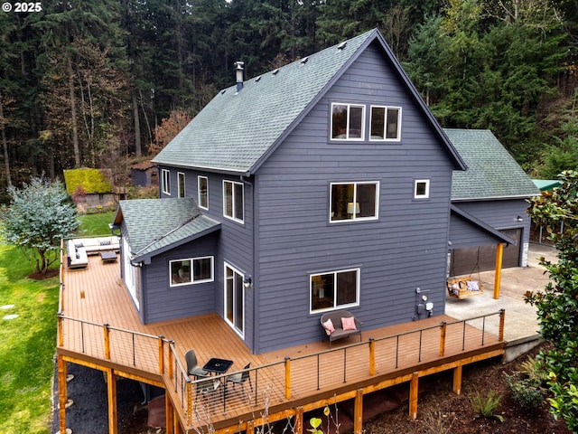 back of house with a garage and a deck