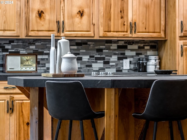 kitchen featuring decorative backsplash and a breakfast bar area