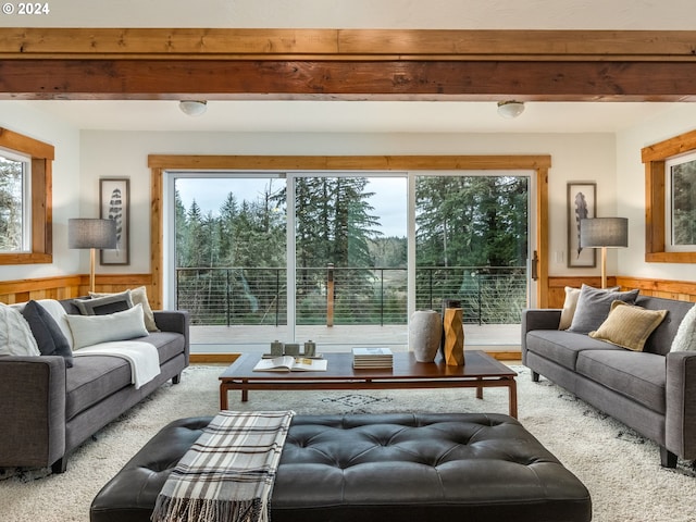 living room featuring plenty of natural light, beamed ceiling, and wood walls