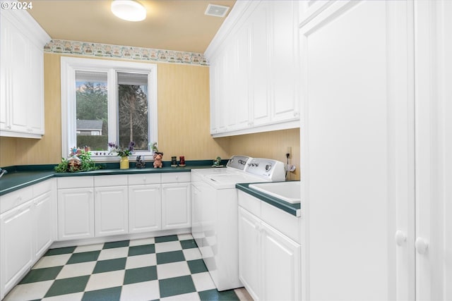 laundry area featuring sink, cabinets, light tile flooring, and washing machine and dryer