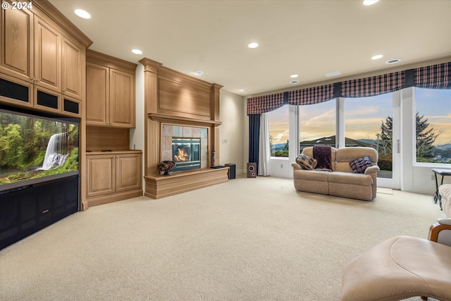 carpeted living room with a wealth of natural light and a fireplace