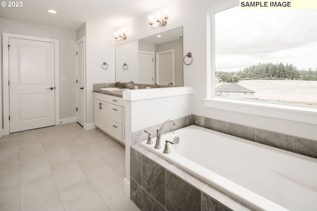 bathroom with tiled bath, tile floors, and vanity with extensive cabinet space